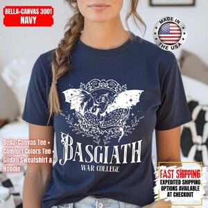 Op de afbeelding: Marineblauw t-shirt met een witte afbeelding van een gevleugeld wezen en de tekst "BASGIATH WAR COLLEGE". Het shirt heeft ook de tekst "BELLA-CANVAS 3001 NAVY" en "MADE IN THE USA".