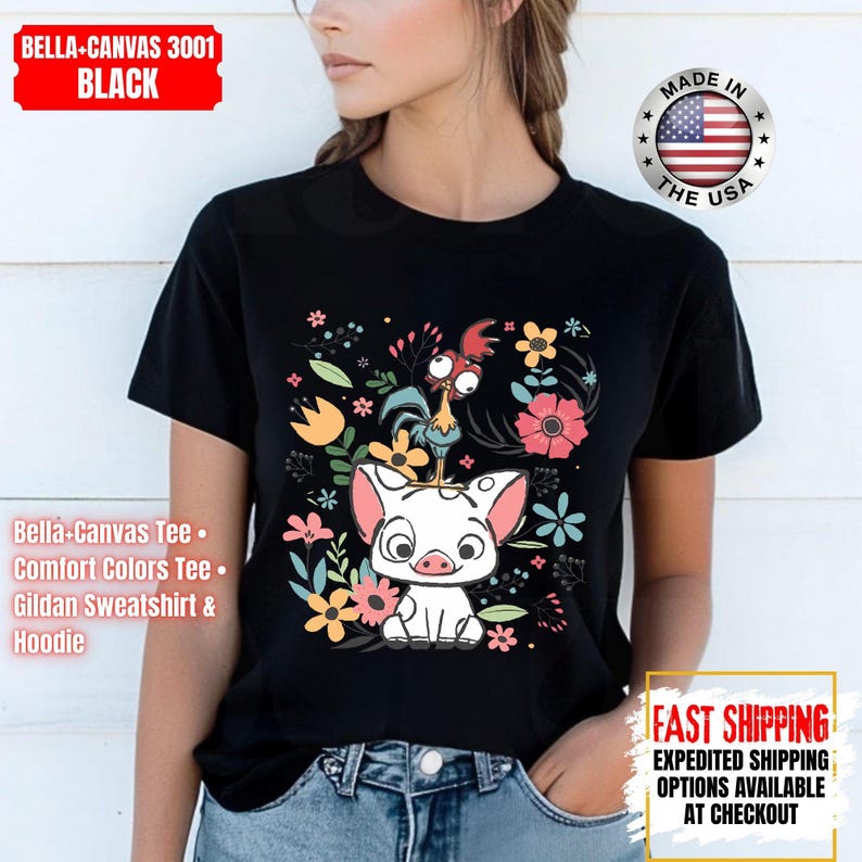 May include: Black t-shirt with a cartoon illustration of a pig, rooster, and flowers. The top of the shirt has the text "BELLA-CANVAS 3001 BLACK". The shirt is a Bella-Canvas Tee, Comfort Colors Tee, or Gildan Sweatshirt & Hoodie.