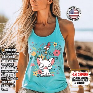 Puede incluir: Camiseta sin mangas azul claro con un dise&ntilde;o de cerdo y gallo de dibujos animados con detalles florales. La camiseta sin mangas tiene un estilo de espalda deportiva y est&aacute; hecha en los EE. UU.
