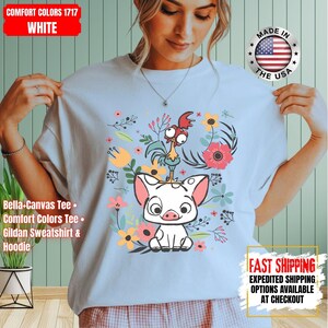 May include: White tee shirt with a cartoon pig and rooster design, surrounded by flowers. The shirt includes the text "COMFORT COLORS 1717 WHITE". Made in the USA. The tee is a Bella+Canvas, Comfort Colors, or Gildan.