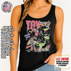 Op de afbeelding: Zwart tanktop met een kleurrijke afbeelding van "Toy Story" met Woody, Buzz Lightyear en Rex. Het ontwerp bevat de tekst "Toy Story" en "Since 1995." Gemaakt in de VS.