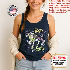 May include: Navy blue vest top with a Buzz Lightyear graphic, the text reads "Buzz Lightyear" and "To Infinity and Beyond." The top has a round neckline and is made in the USA.
