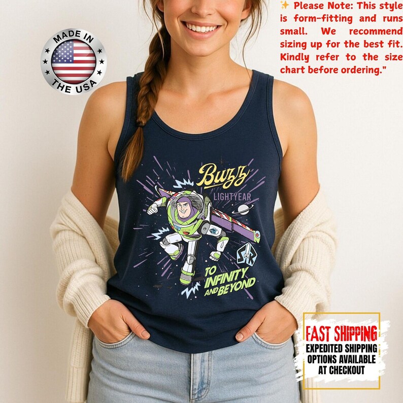 May include: Navy blue vest top with a Buzz Lightyear graphic, the text reads "Buzz Lightyear" and "To Infinity and Beyond." The top has a round neckline and is made in the USA.