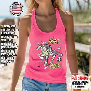 May include: A vibrant pink tank top with a Buzz Lightyear graphic and the words "Buzz" and "To Infinity and Beyond." The tank top has a racerback style and is made in the USA.