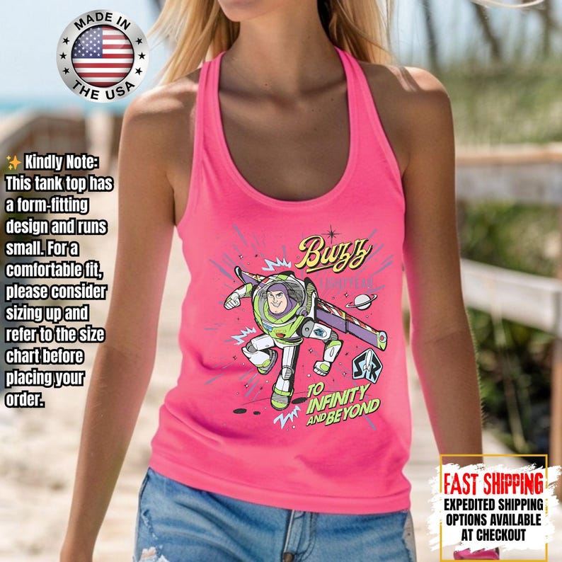 May include: A vibrant pink tank top with a Buzz Lightyear graphic and the words "Buzz" and "To Infinity and Beyond." The tank top has a racerback style and is made in the USA.