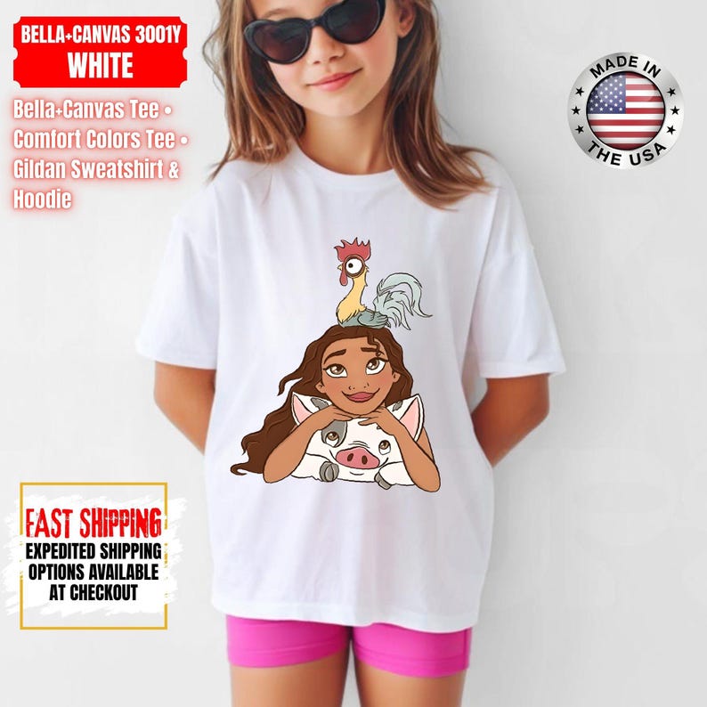 May include: White t-shirt featuring a cartoon illustration of a woman with long brown hair, a pig, and a rooster. The shirt has the text "BELLA-CANVAS 3001Y WHITE" and "FAST SHIPPING". The shirt is made in the USA.