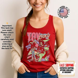 Op de afbeelding: Rode tanktop met een kleurrijke afbeelding van Toy Story-personages en de tekst "TOY STORY SINCE 1995". Het shirt bevat de tekst "MADE IN THE USA" en "FAST SHIPPING".