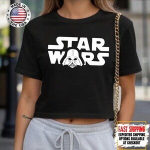 Puede incluir: Top corto negro con el logo blanco de Star Wars y el casco de Darth Vader. Fabricado en EE. UU.
