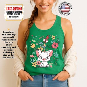 Puede incluir: Camiseta sin mangas verde con una ilustraci&oacute;n de dibujos animados de un cerdo, un gallo y flores. La camiseta sin mangas est&aacute; hecha en los EE. UU. El texto de la imagen dice: "Importante: Esta camiseta sin mangas es peque&ntilde;a. Por favor, compruebe la tabla de tallas cuidadosamente y considere pedir una talla m&aacute;s grande."