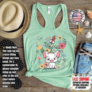 Puede incluir: Camiseta sin mangas verde claro con un gr&aacute;fico de un cerdo y un gallo rodeados de flores. La camiseta sin mangas tiene un dise&ntilde;o de espalda nadadora. Las palabras "MADE IN THE USA" est&aacute;n impresas en un emblema circular. El texto "FAST SHIPPING" tambi&eacute;n es visible.