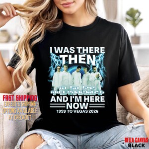 May include: Black t-shirt with a graphic featuring the text "I WAS THERE THEN" above a band image and "IN THE MILLENNIUM 2.0 AND I'M HERE NOW 1999 TO VEGAS 2026". The shirt is made of Bella Canvas black fabric.
