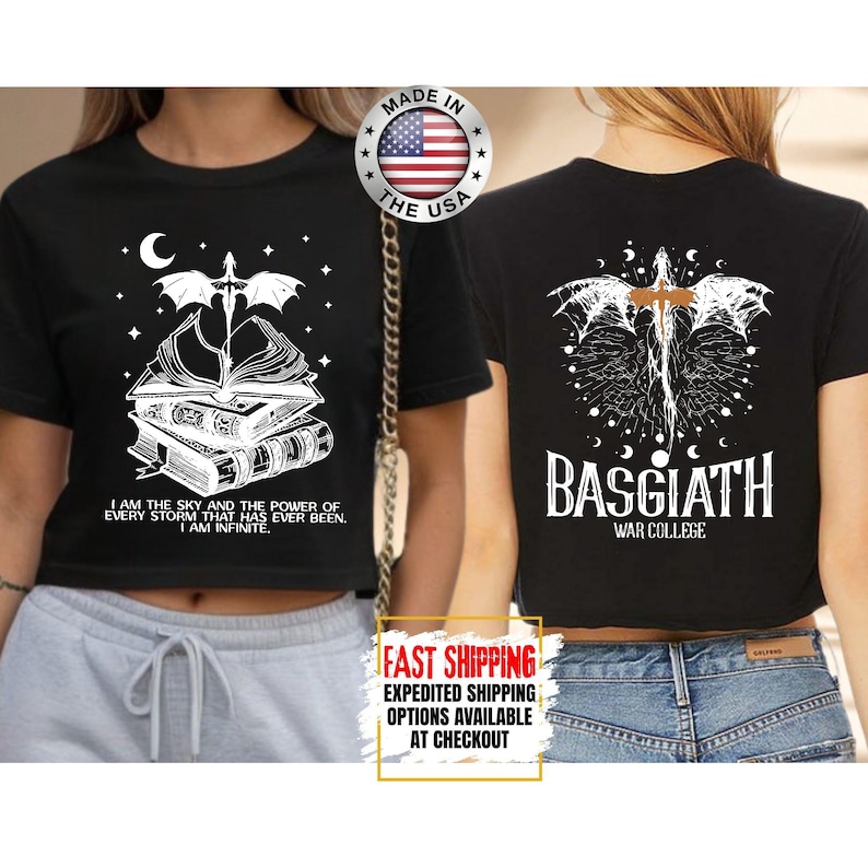 May include: Black crop top with a white graphic of a dragon, books, and text. The front of the shirt has the text "I AM THE SKY AND THE POWER OF EVERY STORM THAT HAS EVER BEEN. I AM INFINITE." The back of the shirt has the text "BASGIATH WAR COLLEGE."