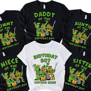 May include: Set of six black and white t-shirts featuring a Teenage Mutant Ninja Turtles graphic. The shirts have text that reads "Mommy of the Birthday Boy", "Daddy of the Birthday Boy", "Auntie of the Birthday Boy", "Niece of the Birthday Boy", "Sister of the Birthday Boy", and "Birthday Boy".