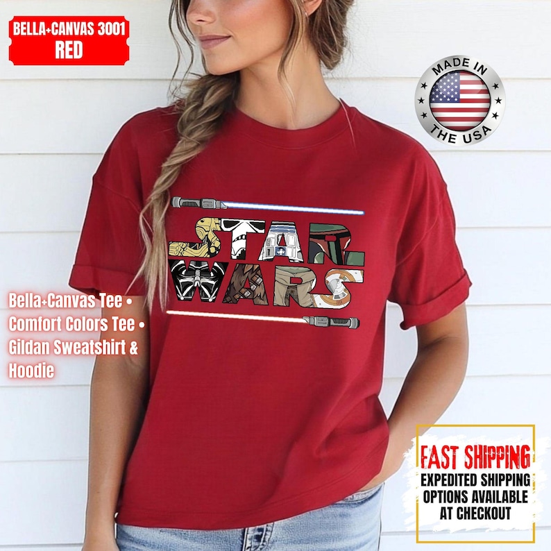 May include: Red t-shirt with the text "STAR WARS" in a colourful, stylised font, with lightsabers. The shirt includes the text "BELLA-CANVAS 3001 RED" and "MADE IN THE USA".