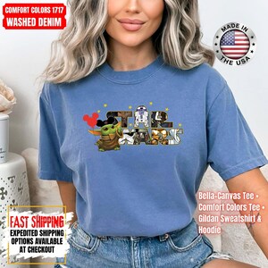 May include: A blue Comfort Colors t-shirt featuring the Star Wars logo with Baby Yoda holding Mickey Mouse balloons. The shirt also has the text "Made in the USA" and "Bella-Canvas Tee, Comfort Colors Tee, Gildan Sweatshirt & Hoodie."