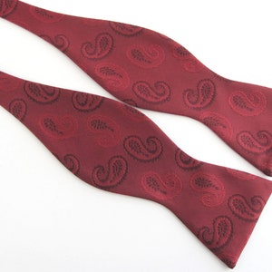 May include: A burgundy bow tie with a paisley pattern.