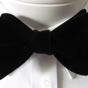 May include: A black velvet bow tie. The bow tie is tied and ready to wear.
