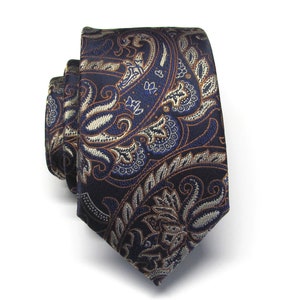 May include: A dark blue paisley patterned tie with brown and silver accents.