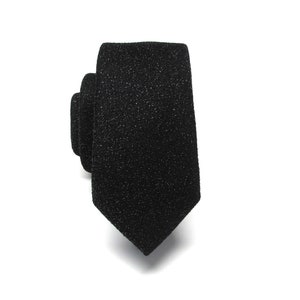 May include: A black tie with a textured, sparkly finish.