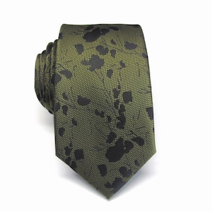 May include: A green tie with a black floral pattern.