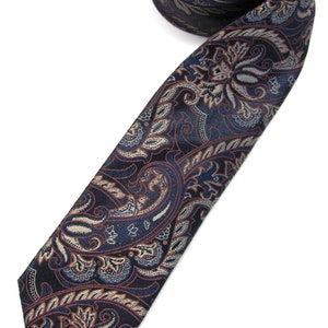 May include: A dark blue paisley patterned tie with a brown and white design.