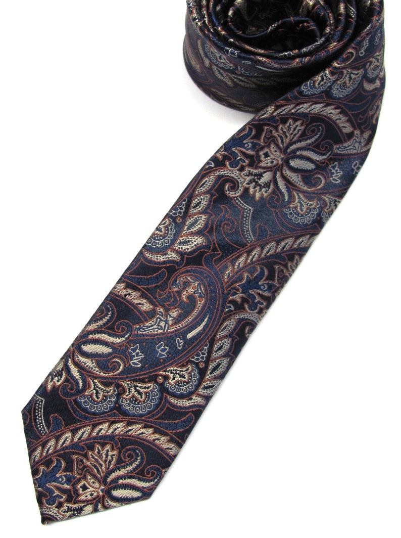 May include: A dark blue paisley patterned tie with a brown and white design.