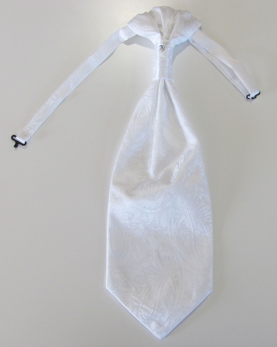 Un uomo in abo grigio e camicia bianca sta aggiustando la cravatta | Foto Premium Un uomo in abo grigio e camicia bianca sta aggiustando la cravatta | Foto Premium