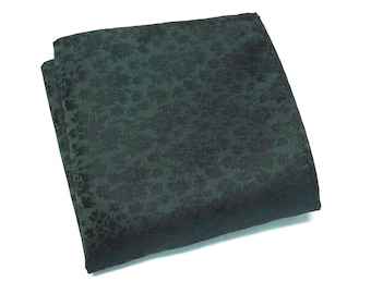 May include: A dark green pocket square with a black floral pattern.