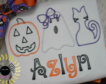 May include: A white t-shirt with an embroidered pumpkin, ghost, and cat. The name "Azlyn" is embroidered in orange and black below the Halloween characters.