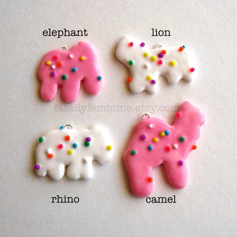 Pu&ograve; includere: Quattro biscotti di zucchero glassati rosa e bianchi a forma di elefante, leone, rinoceronte e cammello. Ogni biscotto &egrave; decorato con codette colorate.
