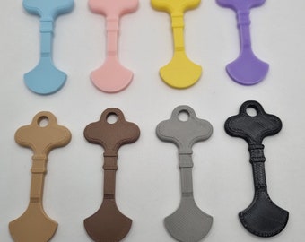 May include: Ten plastic key-shaped charms in various colors, including light blue, pink, yellow, purple, brown, tan, gray, and black.