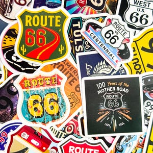 Puede incluir: Una colección de pegatinas coloridas de la Ruta 66. Los diseños incluyen la forma icónica del escudo con "Route 66" y "66" en varias fuentes y colores, junto con texto como "100 Years of the Mother Road".