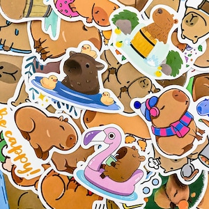 May include: A collection of colorful stickers featuring cartoon capybaras in various activities, including surfing, swimming, and relaxing on a flamingo float. The stickers have a whimsical and playful style, with bright colors and detailed illustrations.