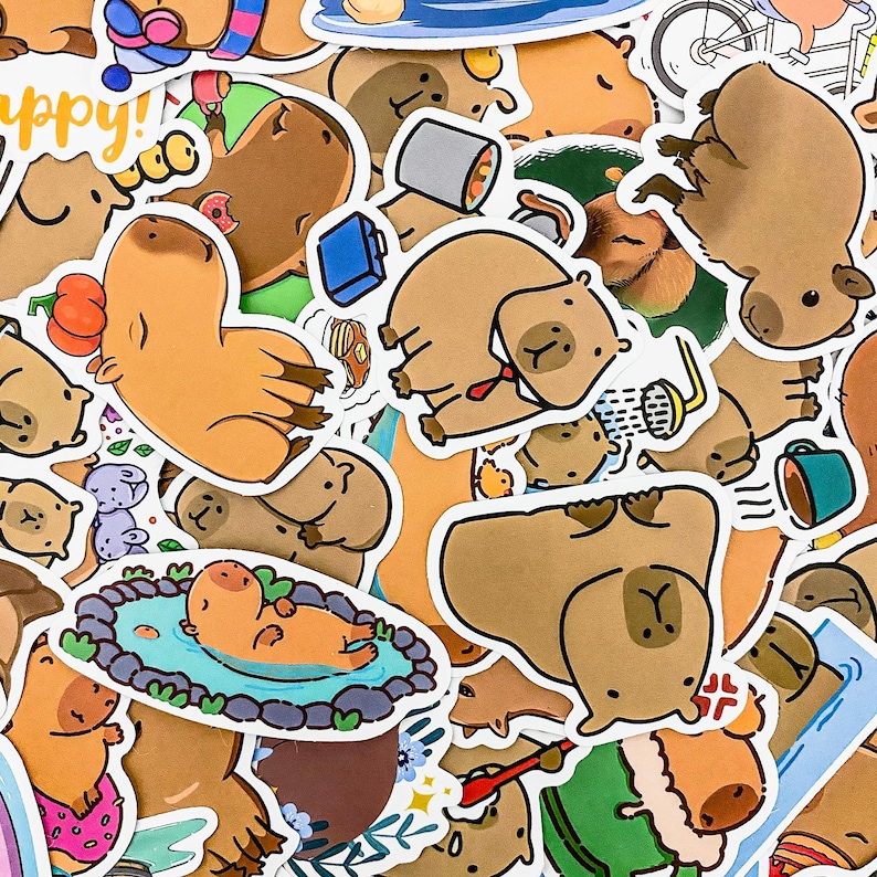 May include: A colorful collection of stickers featuring cartoon capybaras in various poses and settings. The stickers are printed on white paper and have a glossy finish. The stickers include the word "happy!" in a bubble.
