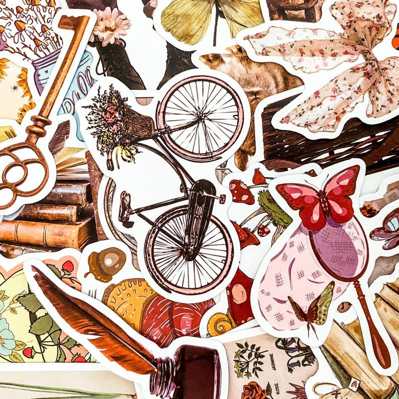 Puede incluir: Una colecci&oacute;n de pegatinas de estilo vintage que incluyen una bicicleta, una mariposa, una pluma de ave, una llave, una pila de libros y un arreglo floral. Las pegatinas est&aacute;n impresas en papel blanco con un aspecto vintage y desgastado.