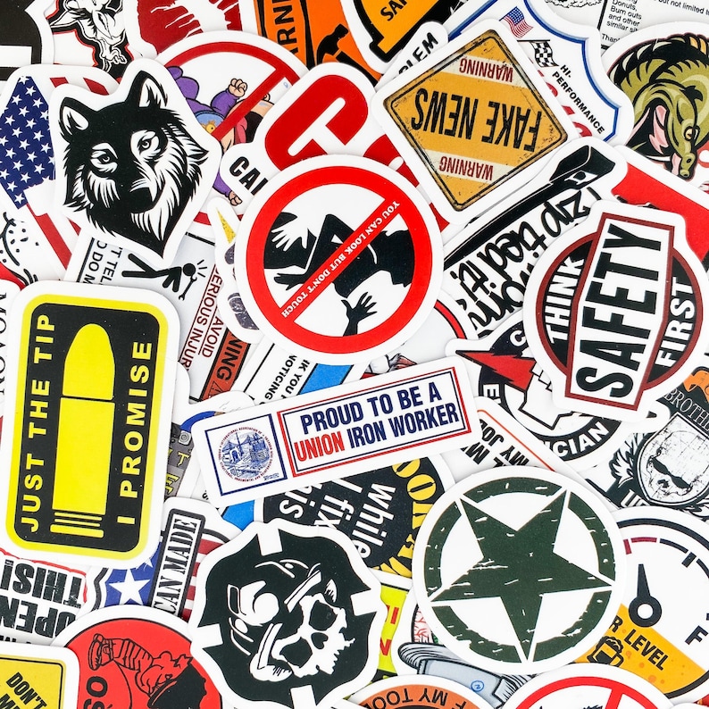May include: A collection of colorful stickers with various designs, including a wolf, a warning sign, a safety sign, a star, and a skull. The stickers are printed on white paper and have a glossy finish.