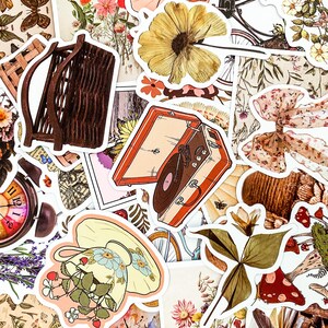 Puede incluir: Una colecci&oacute;n de pegatinas de estilo vintage con varios dise&ntilde;os, que incluyen un tocadiscos, una cesta, una taza con flores y un hongo. Las pegatinas est&aacute;n impresas en papel blanco con un acabado brillante.