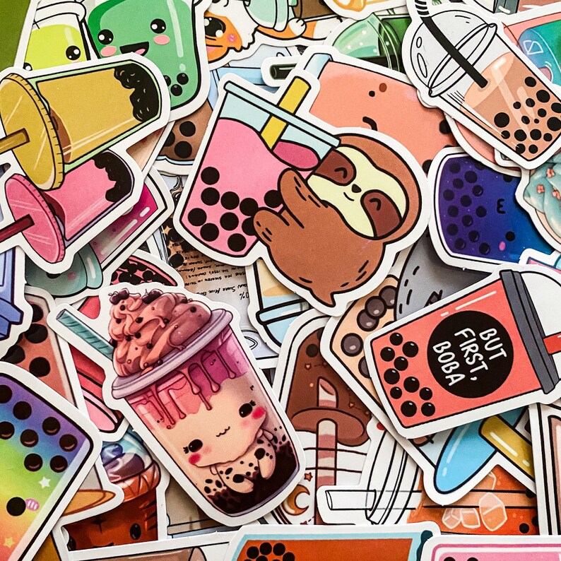 May include: A collection of colorful stickers featuring various designs, including boba tea, sloths, and cartoon characters. The stickers are printed on white paper and have a glossy finish. The text on one sticker reads "But first, boba".