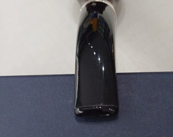 May include: A Savinelli tobacco pipe featuring a dark brown bowl and a black stem. The pipe is positioned on a blue surface, with the Savinelli logo and the year 1876 printed in white.