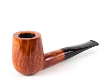 May include: A tobacco pipe featuring a polished, light brown wooden bowl with a visible natural grain pattern and a smooth, black acrylic stem. The bowl has a cylindrical shape with a dark interior, and the stem connects to the bowl with a seamless transition, extending outward to a flat, wide mouthpiece.