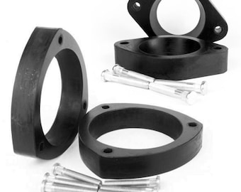 May include: Set of four black rubber car spacers with four silver metal bolts. The spacers are designed to lift a car's suspension.