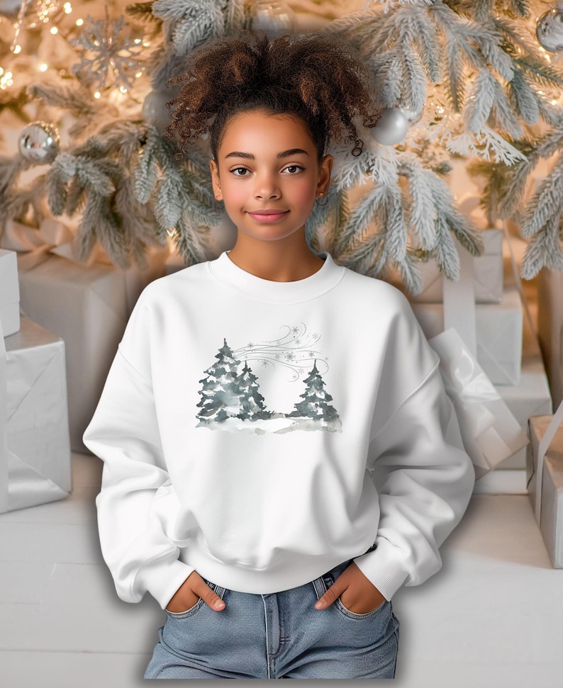 May include: White sweatshirt with a watercolor-style winter scene featuring two evergreen trees and snowflakes. The design is subtle and elegant, perfect for the holiday season. The sweatshirt is a relaxed fit, suitable for casual wear.  It's a comfortable and stylish choice for winter.