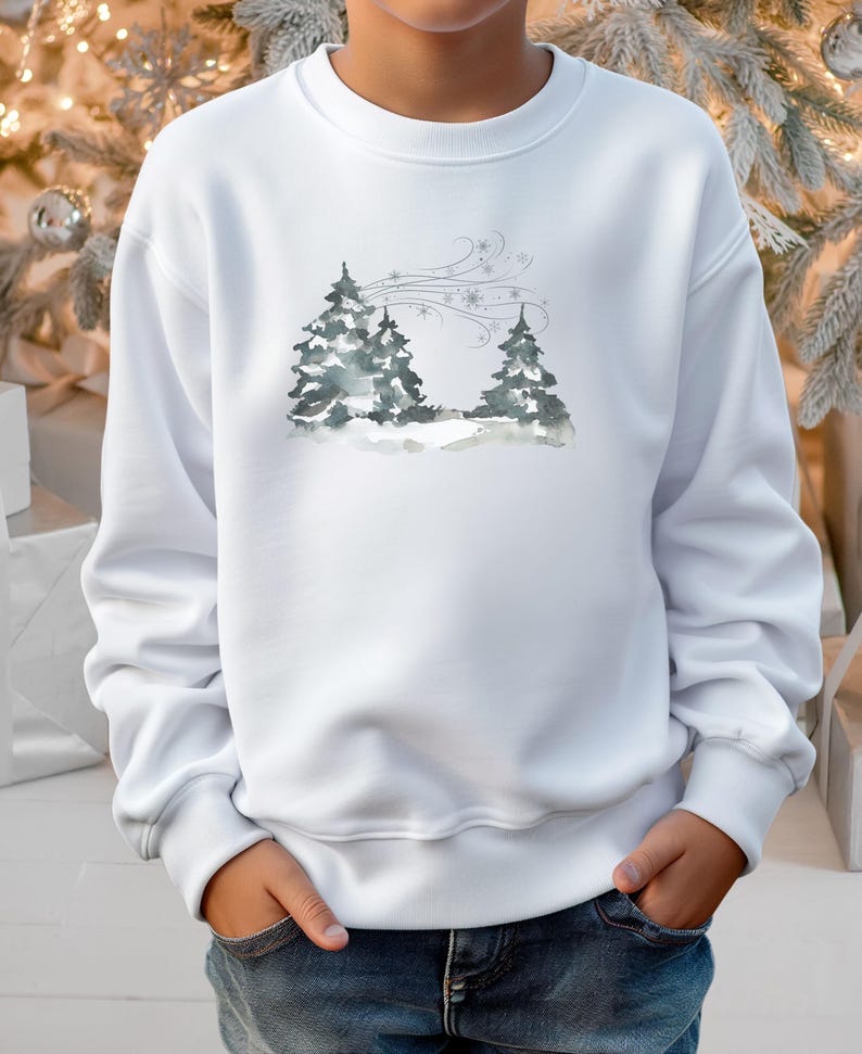 May include: White sweatshirt with a watercolour illustration of two fir trees in a snowy scene, with wind and snowflakes. The design uses grey and blue tones.