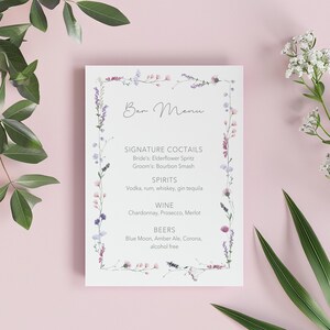 May include: A floral-themed bar menu with the text "Bar Menu" at the top. The menu lists signature cocktails, spirits, wine, and beers. The menu is surrounded by a floral border.
