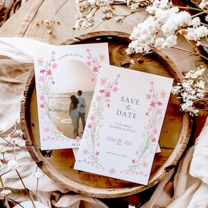 Op de afbeelding: Save the date-kaart met een bloemenontwerp en een foto van een stel op het strand. De kaart staat "Save the Date" voor de bruiloft van Harper & Lucas, zaterdag 23 augustus 2023.