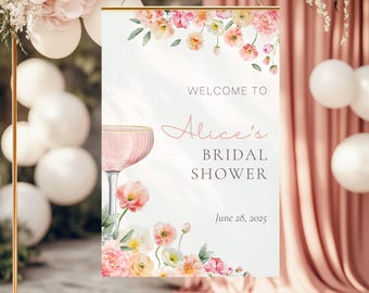 May include: A white bridal shower sign with pink floral designs and a glass of pink champagne. The sign reads "Welcome to Alice's Bridal Shower June 28, 2025".