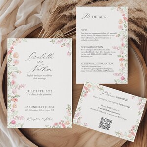 May include: A floral wedding invitation suite with a watercolor design. The invitation features the names "Isabella and Nathan" and the date "July 19th, 2025". The details card includes information about gifts, accommodation, and additional information. The RSVP card includes a QR code and a website address.