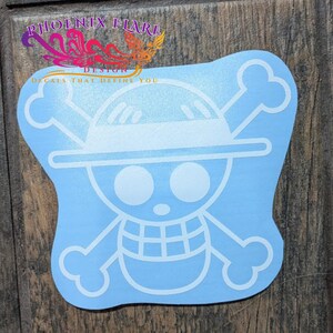 May include: A light blue vinyl decal featuring the white outline of a skull and crossbones wearing a straw hat. The design includes the text PHOENIX FLARE DESIGN DECALS THAT DEFINE YOU in the upper left corner above the graphic icon.