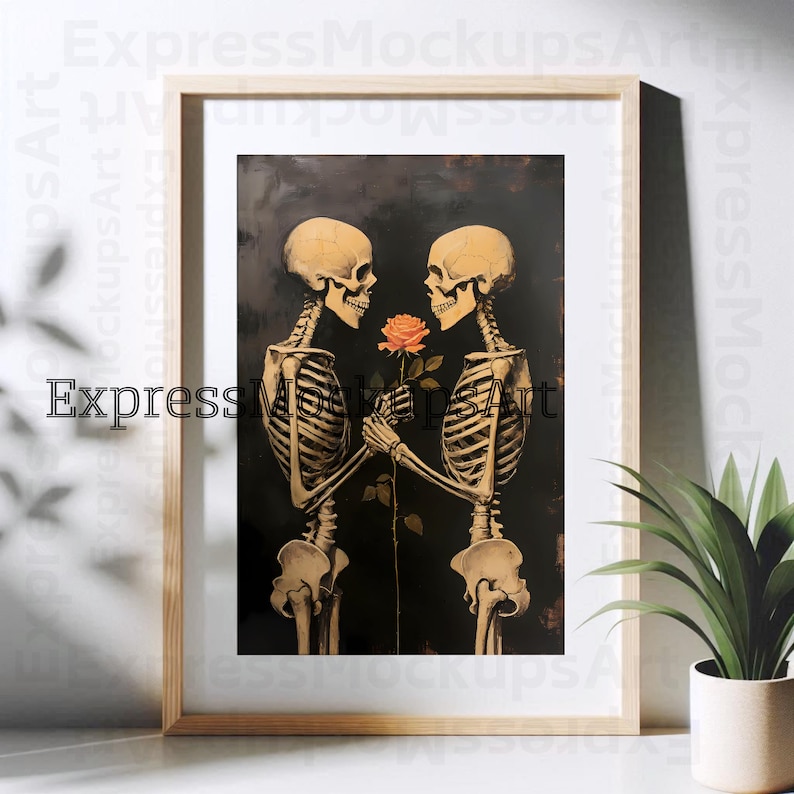 May include: Framed art print showing two skeletons holding an orange rose, set against a dark backdrop. The skeletons are anatomically detailed. The frame is made of light-coloured wood.