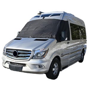 May include: A silver van with a black windshield cover. The van has a black front grill, black tyres, and a black side mirror. The windshield cover is covering the entire windscreen.